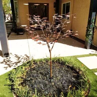our metal tree outdoor sculpture fountains shown here in a backyard enclosure